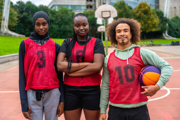 Diverse basketball team standing on urban court