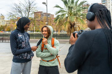 Diverse content creators interviewing man for street media