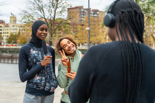 Diverse young friends recording a podcast in urban setting