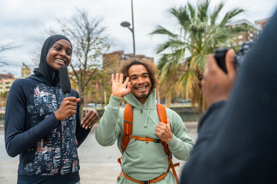 Reporter interviewing man for street journalism video