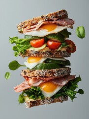 Photograph of a sandwich stacked on top of each other. the sandwich is made with two slices of toasted bread, filled with a variety of ingredients.