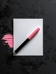 Flat lay of a pink lipstick on a black textured background. the lipstick is placed on a white square with a black cap.
