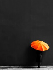 Person standing in front of a black wall, holding an orange umbrella. the person is wearing a black dress and is standing on a tiled floor.