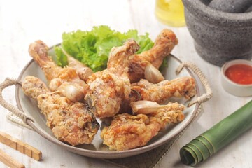 Fototapeta premium Ayam Goreng Bawang Putih. Garlic fried chicken with a crunchy and tasty texture especially with delicious whole garlic