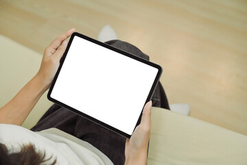 Close up view of a woman using blank screen digital tablet on sofa