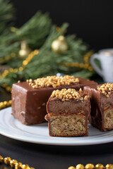 Sliced mousse desserts with hazelnut praline, milk chocolate and covered gourmet chocolate-nut glaze on white plate