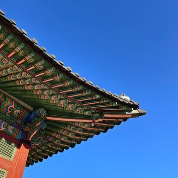 Traditional Korean Palace Roof with Colorful Dancheong Under Clear Blue Sky
