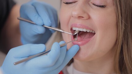 Happy Caucasian female adult receiving dental checkup with dentist using tools. - Powered by Adobe