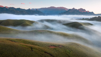 Aerial View landscape of bright sunrise over misty  golden meadow on morning. Phu Hua Lon, Xaysomboun, Laos.