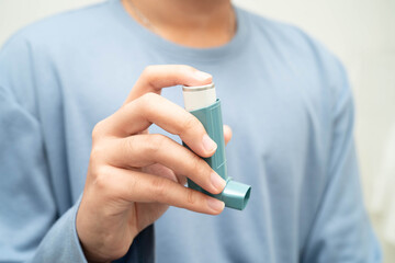 Obraz premium Asthma and chronic obstructive pulmonary disease COPD, Asian teenage using metered dose inhaler MDI.