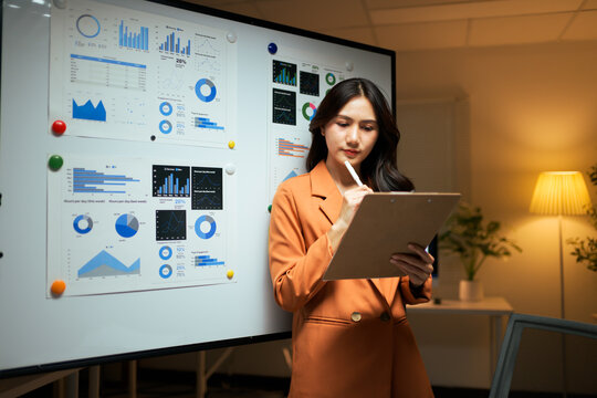 Asian businesswoman analyzing data and planning strategy in office