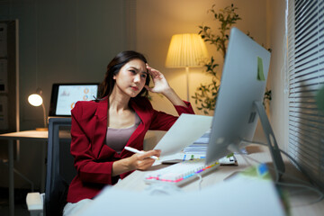 Stressed businesswoman experiencing headache working late at office