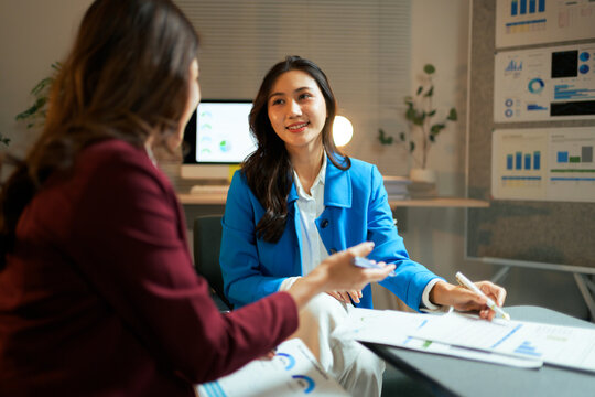 Businesswomen discussing data analysis during an office meeting