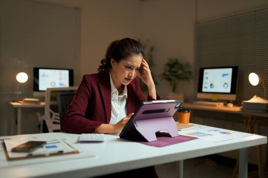 Stressed businesswoman working late at night in office