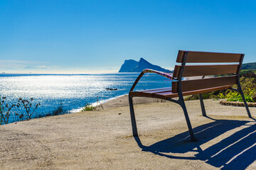 Bench on seashore and Gibraltar rock on horizon