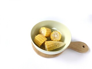 Pieces of corn sitting in a bowl on a white background
