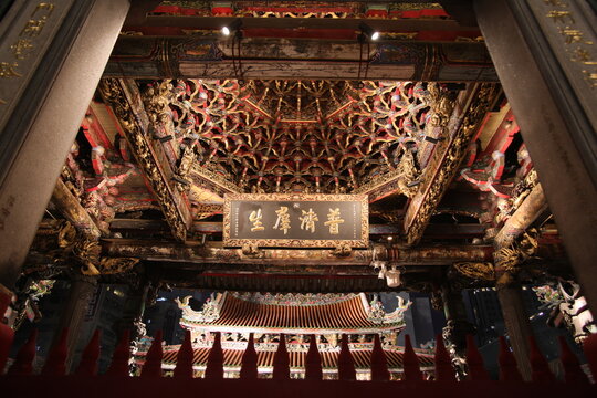 Taipei, Taiwan - November 22th 2025 - Intricate wooden caisson ceiling architecture inside Lungshan Temple.