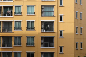 Exterior view of a yellow apartment building with multiple windows and balconies