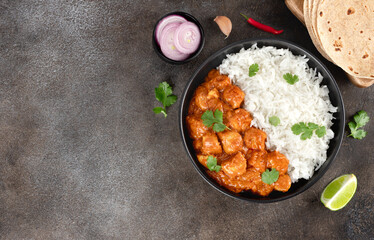 Traditional Indian chicken tikka masala with basmati rice, naan bread on gray background. Top view. Copy space.