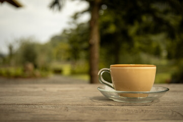 Coffee on a table with greenery behind it