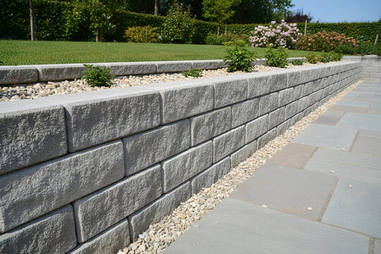 Modern retaining wall with plants and gravel in a landscaped garden