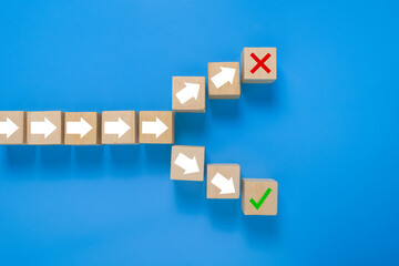 arrow symbol on wooden blocks splitting into right and wrong direction. concept of choosing right or wrong way