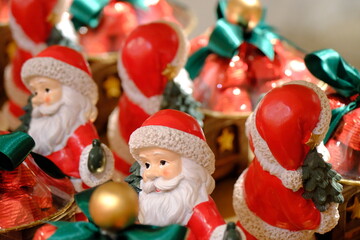 Christmas chocolates with Santa Claus figures. Gift chocolates with red packaging, green ribbons, and yellow balls. Happy New Year. Welcome 2026. Merry Christmas.