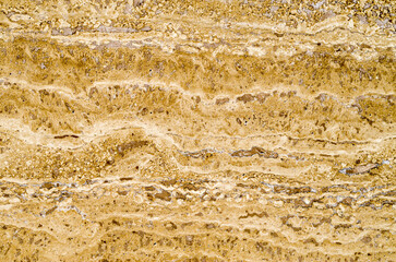 Yellow polished stone closeup on wall