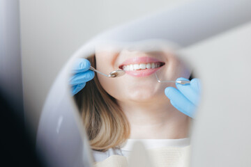 Caries treatment concept, Caucasian young female at dental checkup with dentist in blue gloves in stomatology clinic