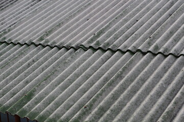 Close-up view of a weathered corrugated roof with a diagonal pattern