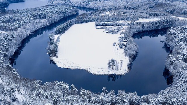 Aerial view of winter nature. Winter river and snowy forest.