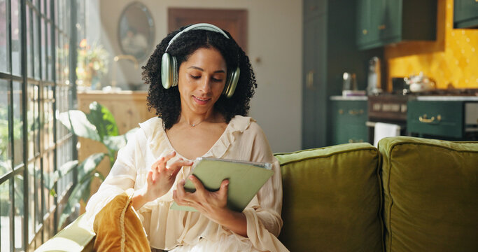 Headphones, tablet and woman on sofa in house with listening to music, radio or song on app. Digital technology, relax and female person streaming playlist, podcast or album online in living room.