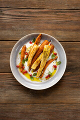 Top view of roasted carrot and parsnip wooden surface