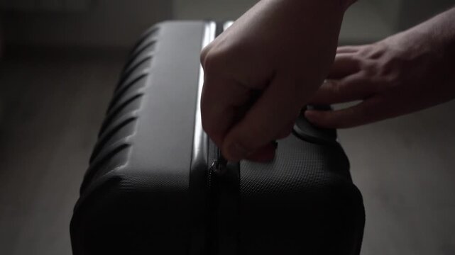 Close-Up of a Stylish Black Suitcase with a Hand Resting on It, Highlighting Minimalist Design and Practicality for Modern Travel Needs. Video with sound.