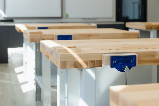 Woodworking classroom filled with well-lit workbenches designed for crafting projects