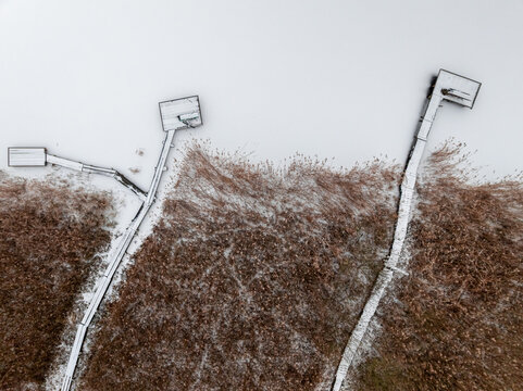 Aerial view of snow-covered jetty over lake in winter.
