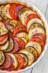 Round baking pot filled with circularly arranged baked vegetable ratatouille