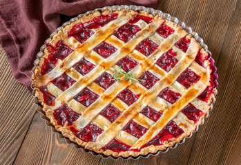 Freshly baked lattice-top cherry pie resting beautifully on rustic wooden surface