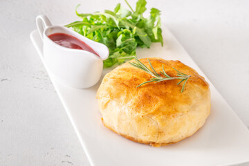 Golden Camembert en Croûte with rosemary sprig and deep red cranberry sauce