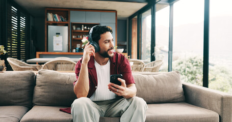 Music, phone and thinking with man on sofa in living room of home for me time or wellness. App,...