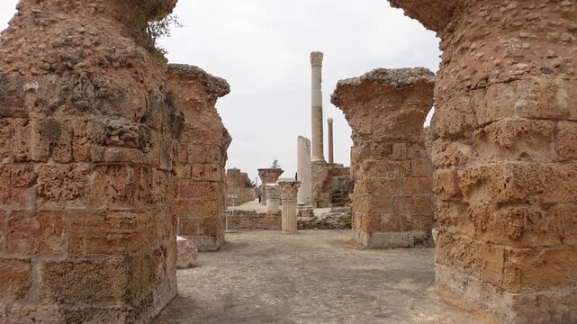 Walking through pillars of ancient city of Carthage, archaeology and historic landmark in Tunisia
