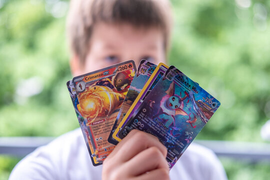 Child holding Pok&eacute;mon trading cards, focus on cards, Card Collection, Childhood Hobbies, youth culture and leisure, Gaming and Fan Entertainment, Battle with friends, Frankfurt - May 30, 2025