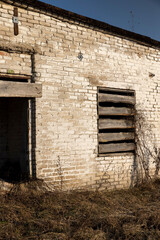 Fototapeta premium an abandoned building made of brick in the winter, an abandoned building intended for demolition, the entrances and windows to the building are boarded up