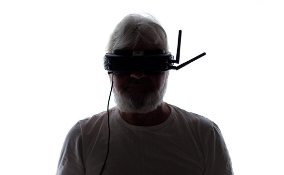 Bearded senior pilot with FPV goggles and drone controller on white isolated background, modern male hobby and technological progress concept