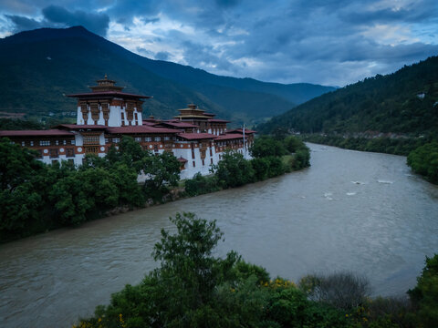 Aerial view of the majestic Punakha Dzong stands proudly where the Mo Chhu and Pho Chhu rivers meet under a dramatic sky, Punakha, Punakha, Bhutan.