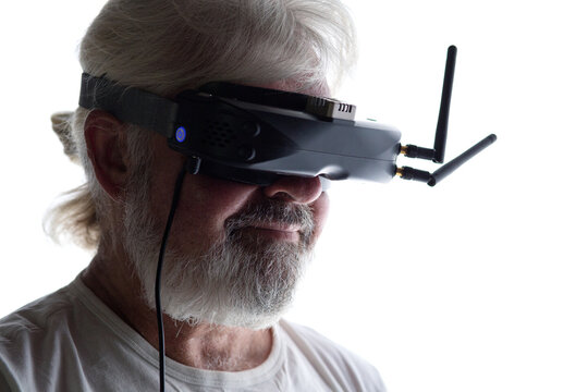 head profile of bearded elderly man operating FPV drone in googles on his head, studio shot of man and modern technologies