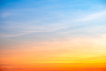 Sunset or sunrise sky with a vibrant gradient of orange, gold, and soft blue. Clear atmosphere with wispy clouds. Peaceful, natural light background. hope, freedom, new day and inspirational Concepts