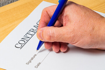 Signing a contract, businessman puts signature on document
