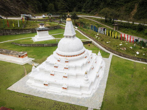 Aerial view of the gleaming white Chendebji Chorten Stupa stands in stark contrast to the vibrant prayer flags fluttering in the breeze, Chendebji village, Trongsa, Bhutan.