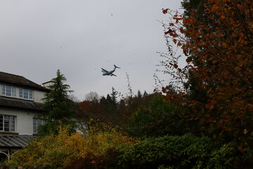Unmarked Military refueling transport plane disturbs birds flying low in the English Lake District National Park.
